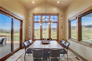 Carpeted dining room featuring plenty of natural light, vaulted ceiling, and golf course views