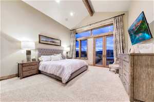 Second Master Bedroom suite on main level with lofted ceiling with beams, french doors to deck, and light carpet