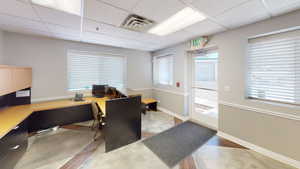 Hardwood floored home office with a drop ceiling