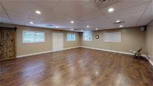 Unfurnished room with a drop ceiling and dark hardwood floors