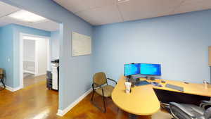 Home office featuring a drop ceiling and light hardwood flooring