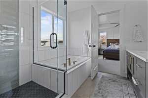 Bathroom with separate shower and tub, vanity, and light hardwood floors
