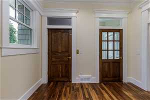 Wood floored entrance foyer featuring crown molding