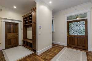 Hardwood floored foyer featuring crown molding