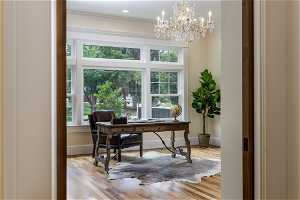 Wood floored office space with a wealth of natural light and ornamental molding