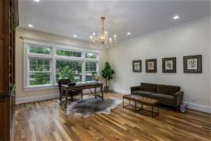 Office area featuring a chandelier, hardwood floors, and crown molding