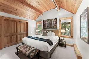 Bedroom with multiple windows, light carpet, wooden ceiling, and lofted ceiling with beams