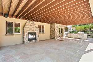 Covered patio with 2-way fireplace off of the basement kitchen and under the main-floor deck.