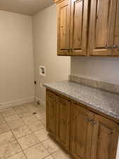 Laundry area featuring light tile flooring