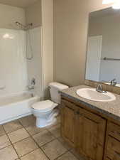 Full bathroom featuring oversized vanity,  shower combination, mirror, and light tile floors