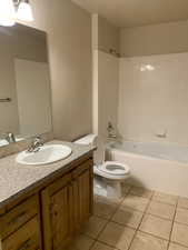 Full bathroom with washtub / shower combination, oversized vanity, light tile flooring, and mirror