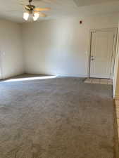 Spare room featuring light carpet and ceiling fan