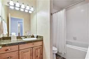 Full bathroom featuring tile floors, shower / tub combo with curtain, mirror, and large vanity