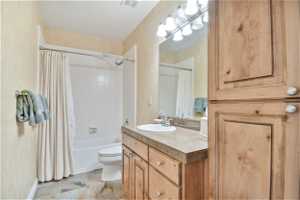 Full bathroom with shower / tub combo, light tile flooring, mirror, and vanity