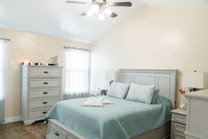 Hardwood floored bedroom featuring lofted ceiling and ceiling fan