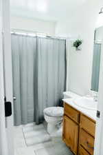 Bathroom with oversized vanity, light tile flooring, and mirror