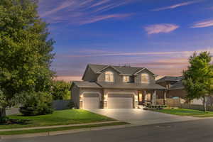 View of front of property featuring garage and a yard