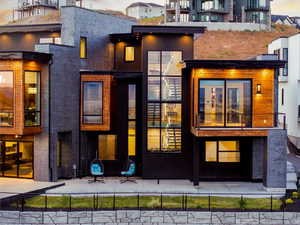 Back house at dusk with a balcony and a patio area