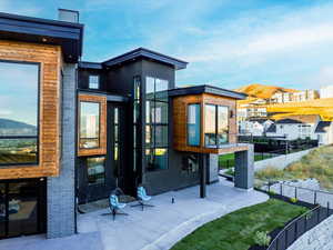 Back of property with a mountain view and a patio area