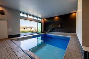 View of indoor swimming pool with sliding doors that slide all the way open to the backyard,