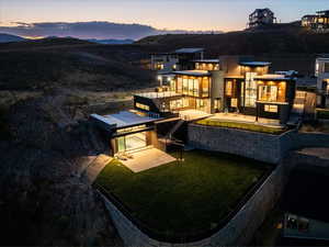 Back house at dusk featuring a patio