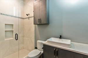 Bathroom featuring a shower with shower door and vanity