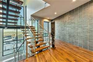 Stairway with a wealth of natural light and light hardwood floors