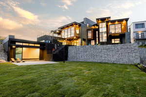 Back house at dusk with a patio and a yard