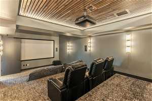 Carpeted home theater with wood ceiling