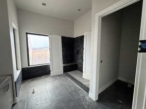 Bathroom featuring a shower and tile walls