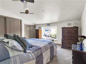 Carpeted bedroom with vaulted ceiling, a closet, and ceiling fan
