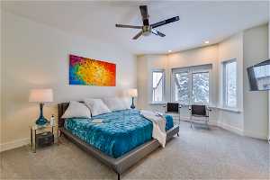 Master bedroom upstairs featuring multiple windows and ceiling fan