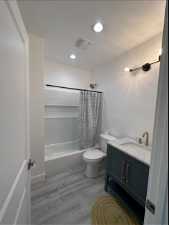 Full bathroom featuring toilet, shower / tub combo  and vanity