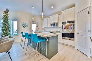 Kitchen with, white cabinets, , an island with sink,