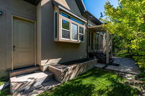 Property entrance featuring a patio area and a yard