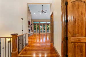 Corridor with wood-type flooring and lofted ceiling