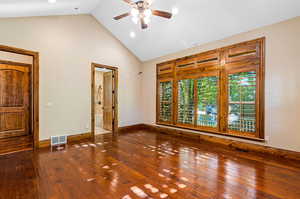 Hardwood floored spare room featuring vaulted ceiling high and ceiling fan