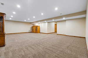 Basement featuring light carpet