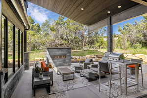 View of patio with an outdoor living space with a fireplace