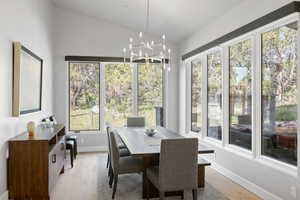 Dining space featuring a healthy amount of sunlight, vaulted ceiling, and light hardwood / wood-style flooring