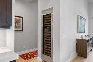 Interior space featuring wine cooler and light hardwood / wood-style flooring