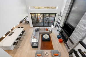 Living room with a towering ceiling and hardwood / wood-style flooring