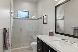 Bathroom with an enclosed shower, vanity, and toilet