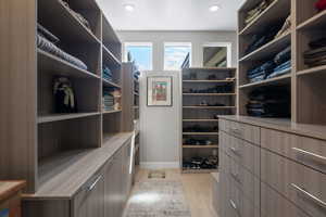 Spacious closet with light hardwood / wood-style flooring