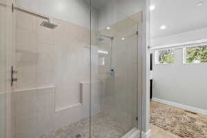 Bathroom with an enclosed shower and tile flooring