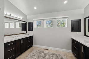 Bathroom featuring vanity, tile floors, and lofted ceiling