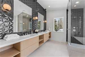 Bathroom featuring an enclosed shower, double vanity, tile floors, and vaulted ceiling