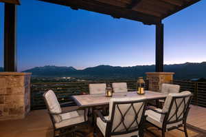 Patio terrace at dusk with a balcony and a mountain view