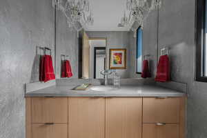 Guest bath with custom wall treatment and antique wall sconces.