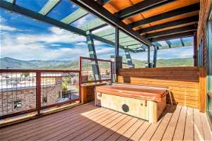 Wooden deck with a mountain view and a covered hot tub